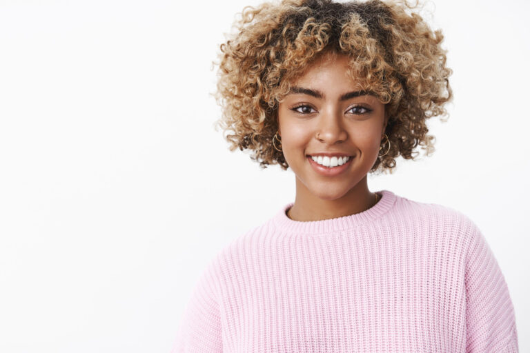 close up shot charismatic friendly looking happy nice dark skinned girl with pierced nose perfect smile standing delighted cute white wall sweater enjoying family holiday dinner